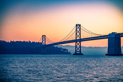 Bay bridge against clear sky at sunrise