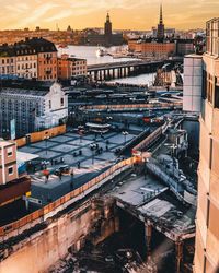 High angle view of buildings with bridge over river in city against sky