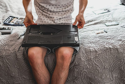 A young man is changing the thermal paste on a laptop.