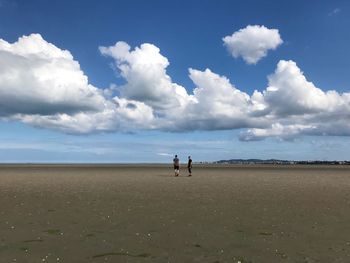 People on beach against sky