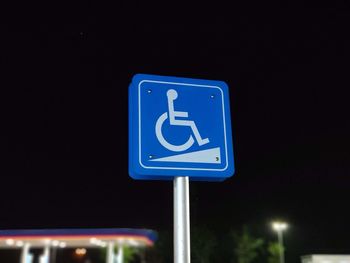Low angle view of information sign against clear blue sky