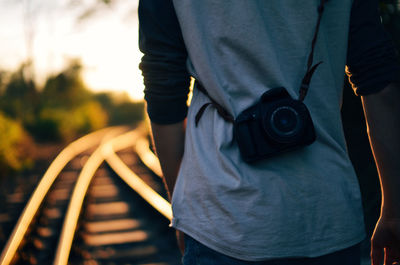 Midsection of man holding camera