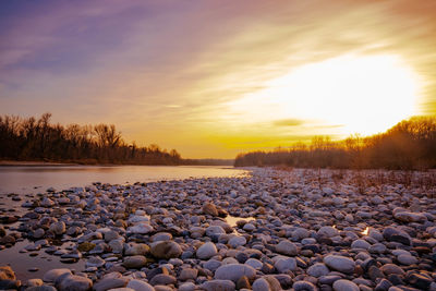 Scenic view of frozen lake against sky during sunset