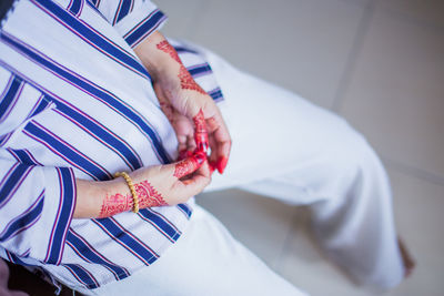 High angle view of woman holding hands on bed