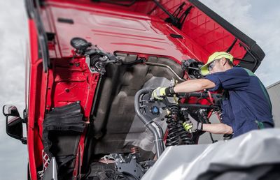 Low angle view of mechanic repairing truck