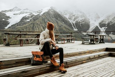 Rear view of man standing on snowcapped mountain