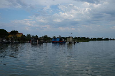 Scenic view of river by buildings against sky