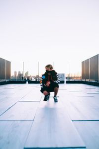 Full length portrait of man sitting against sky