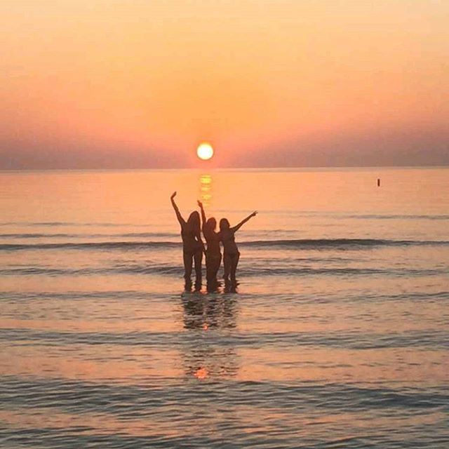 sunset, sea, water, horizon over water, silhouette, orange color, sun, scenics, leisure activity, men, beauty in nature, lifestyles, sky, tranquil scene, tranquility, togetherness, idyllic, beach, nature