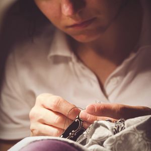 Midsection of woman sewing clothes