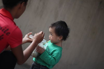 Cropped image of mother feeding food to baby