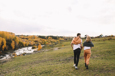 Happy people in love are travel hike in nature in the autumn forest. romantic trip to countryside