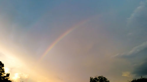 Low angle view of rainbow against sky at sunset