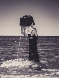 Man standing by sea against clear sky