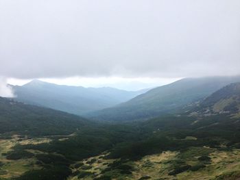 Scenic view of mountains against cloudy sky