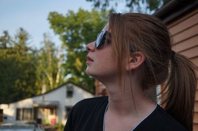 Young woman wearing sunglasses outside house