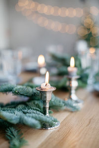 Close-up of lit candles on table christmas decorations on table