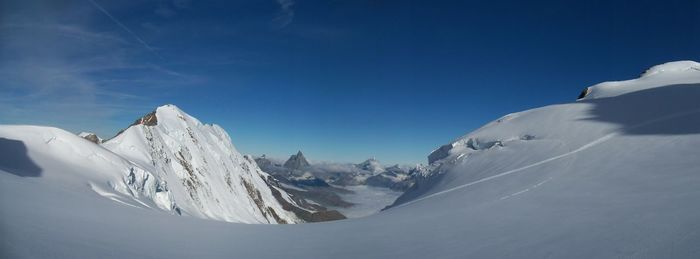 Scenic view of snowcapped mountains against blue sky