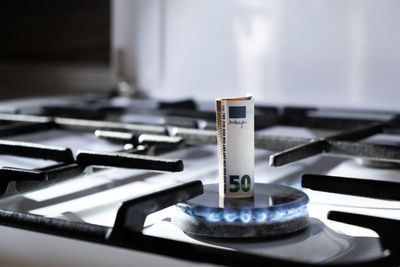 Close-up of banknote on gas stove burner