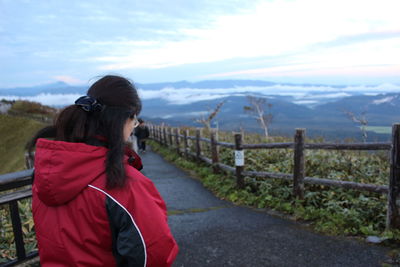 Woman standing on road against mountains