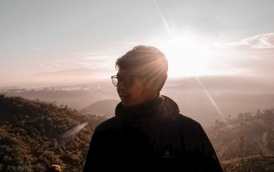 Portrait of man looking at mountains against sky