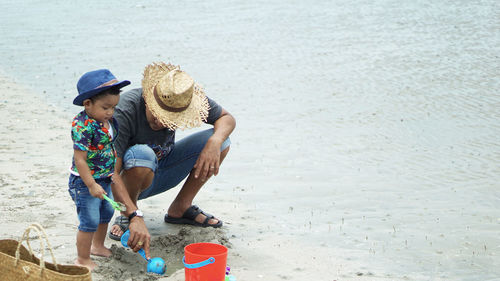 Father and son playing with sand at beach