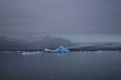 Scenic view of lake against sky during winter