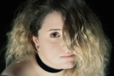 Close-up portrait of young woman covering face with hair