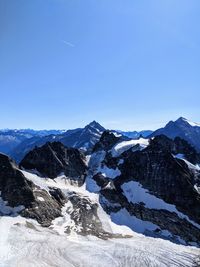 Scenic view of snowcapped mountains against clear blue sky