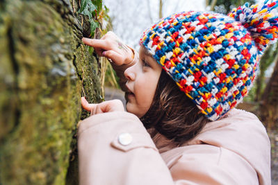 A young girl on a nature hike in winter searching for bugs