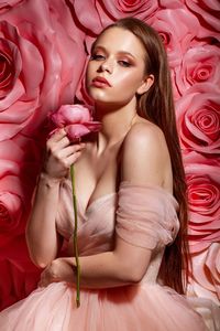 Woman with pink flower petals on bed