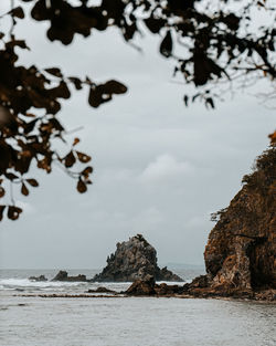 Rocks in sea against sky