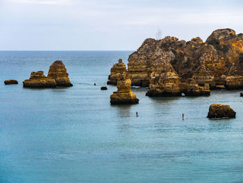 Scenic view of rocks in sea against sky