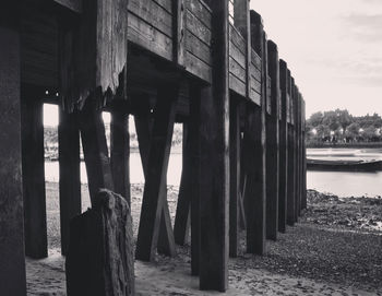 Wooden posts in sea against sky