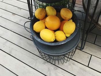 High angle view of fruits in container on wooden table