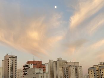 Buildings in city against sky during sunset