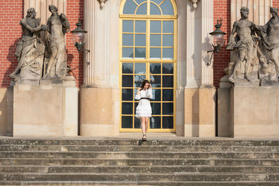 Statue of woman against building