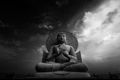 Low angle view of buddha statue against sky