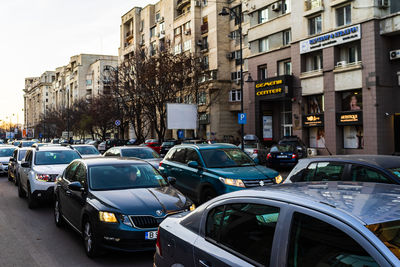 Cars on road by buildings in city