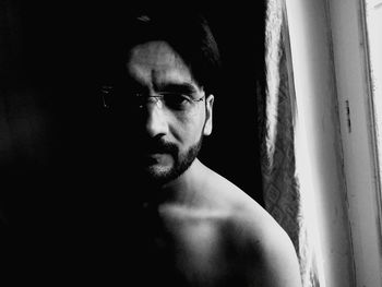 Portrait of young man looking through window