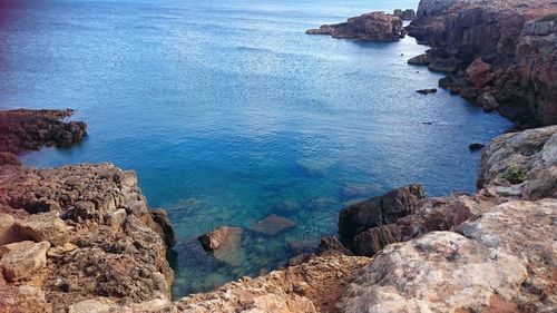 High angle view of rock formation by sea against sky