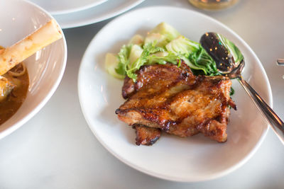 High angle view of meat with vegetables served in bowl on table