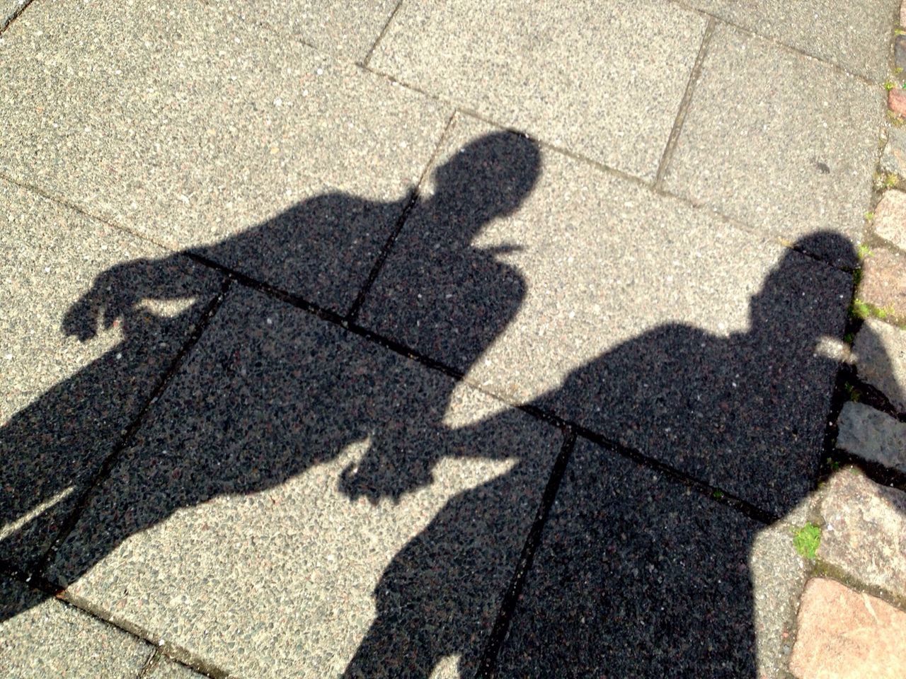 shadow, high angle view, street, focus on shadow, sunlight, lifestyles, men, paving stone, cobblestone, sidewalk, unrecognizable person, low section, road, leisure activity, footpath, outdoors, standing, day