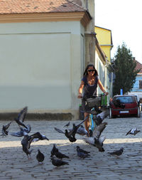 Full length of young woman with birds