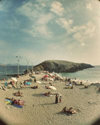 Panoramic view of people on beach against sky