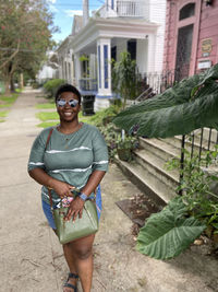 Portrait of smiling young woman standing against building