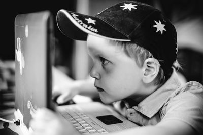 Cute boy surfing on laptop at home