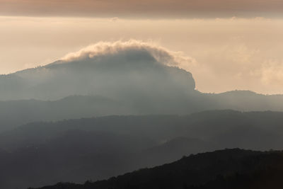 Scenic view of silhouette mountains against sky during sunset