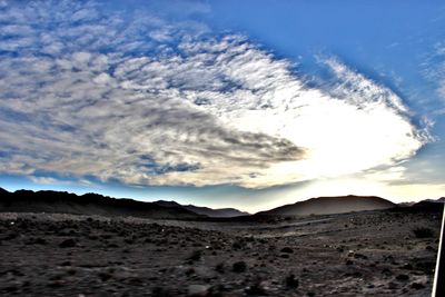 Scenic view of mountains against cloudy sky