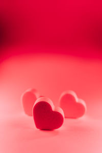 Close-up of red heart shape over pink background